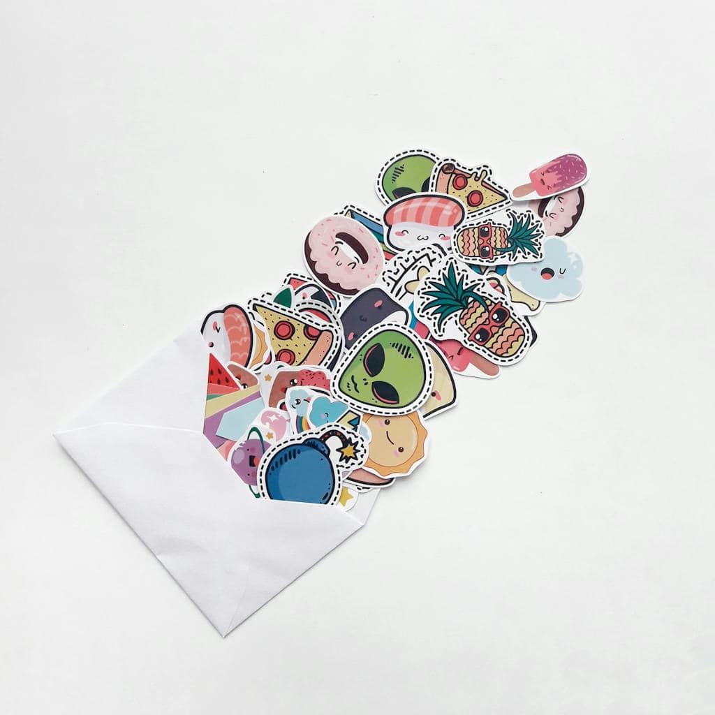shopping for collectible stickers. An array of colorful cartoon stickers spilling out of a white envelope, featuring food and fun designs.
