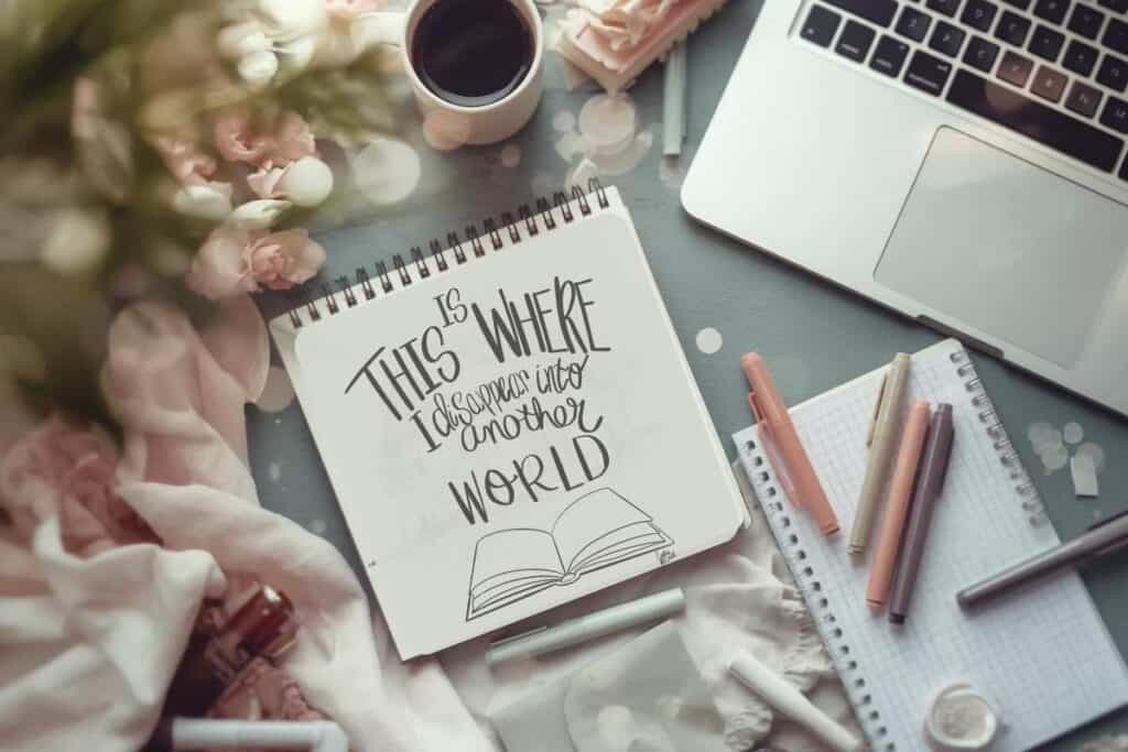  A cozy flatlay of sketchbook, notes, laptop and art supplies representing capturing creative ideas out of chaos learning to monetize your digital art
