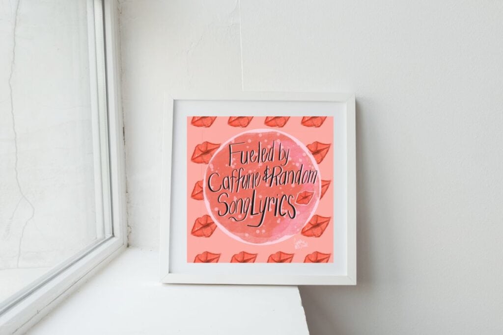 A framed 12x12 wall art print with a pink background and red lips pattern sits on a white windowsill; the artwork reads "Fueled by Caffeine & Random Song Lyrics."